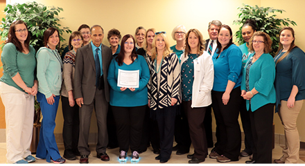 Group of staff wearing teal shirts or accessories to increase awareness of cervical cancer.